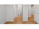 Hallway leading to bathroom featuring hardwood floors, neutral paint, and white trim at 19595 N 107Th Dr, Sun City, AZ 85373