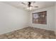 Bright bedroom featuring a ceiling fan, tile flooring, and a window that allows natural light to illuminate the space at 2106 E 39Th Ave, Apache Junction, AZ 85119