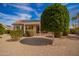 Landscaped backyard with a covered patio, lush greenery, and desert landscaping at 21402 N 158Th Dr, Sun City West, AZ 85375