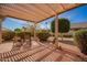 Covered patio with seating area surrounded by greenery and manicured landscaping at 21402 N 158Th Dr, Sun City West, AZ 85375