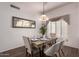 Cozy dining room with a stylish mirror, light fixture, and shuttered window at 21402 N 158Th Dr, Sun City West, AZ 85375