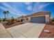 Charming home with desert landscaping, a paver driveway, a tile roof, and a gray two-car garage at 21402 N 158Th Dr, Sun City West, AZ 85375