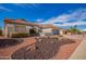 Inviting home with desert landscaping, featuring red rock accents, a tile roof, and a gray two-car garage at 21402 N 158Th Dr, Sun City West, AZ 85375