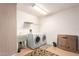 Bright laundry room featuring a utility sink, washer, dryer, overhead rack, and tile flooring at 21402 N 158Th Dr, Sun City West, AZ 85375