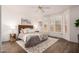 Cozy bedroom featuring hardwood floors, a large window with shutters, a ceiling fan, and soft, neutral decor at 21402 N 158Th Dr, Sun City West, AZ 85375