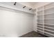 Empty walk-in closet includes shelving units, closet rod, and carpeted floor at 21402 N 158Th Dr, Sun City West, AZ 85375