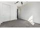 Neutral bedroom featuring neutral carpet, fan, and modern closet with sliding doors at 21978 N 97Th Dr, Peoria, AZ 85383