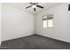 Minimal bedroom featuring neutral carpet, fan, and a window providing natural light at 21978 N 97Th Dr, Peoria, AZ 85383