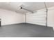 Spacious garage with painted floor, white walls and an automatic door provides ample parking at 21978 N 97Th Dr, Peoria, AZ 85383