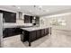 Modern kitchen featuring a large island, dark wood cabinets, and stainless steel appliances at 21978 N 97Th Dr, Peoria, AZ 85383