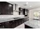 Kitchen with gas cooktop, stainless steel appliances, and dark wood cabinets at 21978 N 97Th Dr, Peoria, AZ 85383