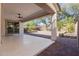 A covered patio with ceiling fan overlooks a brick-paved terrace with lush landscaping at 21978 N 97Th Dr, Peoria, AZ 85383