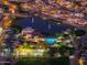 Aerial view of a vibrant community at night, showcasing lighted amenities and well-lit streets at 2215 E La Costa Dr, Gilbert, AZ 85298