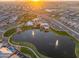 Aerial view of community with a lake, pool, and clubhouse, showcasing a vibrant lifestyle at 2215 E La Costa Dr, Gilbert, AZ 85298