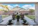 Beautiful backyard view from covered patio, featuring seating, outdoor fireplace, manicured lawn, and privacy fence at 2215 E La Costa Dr, Gilbert, AZ 85298