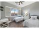 Cozy bedroom with twin beds, window with shutter, desk, ceiling fan, and neutral-toned carpet at 2215 E La Costa Dr, Gilbert, AZ 85298