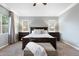 Serene main bedroom featuring a dark wood bed frame, neutral colors, and large windows at 2215 E La Costa Dr, Gilbert, AZ 85298