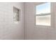 Bright bathroom with a white subway tile surround, a tiled soap niche, and a window at 2219 N 13Th St, Phoenix, AZ 85006