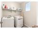 Bright laundry room with modern, white washer and dryer, complemented by built-in shelving and ample storage space at 22962 N 182Nd Ln, Surprise, AZ 85387