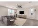 Bright living room featuring a large sectional sofa, ceiling fan, and tile flooring at 22962 N 182Nd Ln, Surprise, AZ 85387