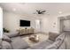 Bright living room featuring a large sectional sofa, ceiling fan, and tile flooring at 22962 N 182Nd Ln, Surprise, AZ 85387