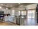 Bright, open kitchen featuring white cabinets, stainless steel appliances, and seamless transition into the cozy living room at 2393 E San Gabriel Trl, Casa Grande, AZ 85194