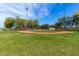 Well-maintained community baseball field with green grass, trees, and clear blue skies at 25913 W Sands Dr, Buckeye, AZ 85396