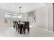 Bright dining room with a dark wood table, seating for eight and light tile flooring at 25913 W Sands Dr, Buckeye, AZ 85396