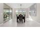 Bright dining room boasts tile floors, a modern light fixture, and sliding glass door to the backyard at 25913 W Sands Dr, Buckeye, AZ 85396