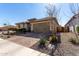 View of the home's facade with a well-kept yard, desert landscaping, and a driveway leading to a 2 car garage at 25913 W Sands Dr, Buckeye, AZ 85396