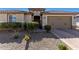 Inviting single-story home with desert landscaping, an arched entryway and a private attached two-car garage at 25913 W Sands Dr, Buckeye, AZ 85396