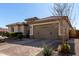 View of the home's front facade with a well-kept desert landscape and a driveway leading to a 2-car garage at 25913 W Sands Dr, Buckeye, AZ 85396