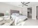 Well-lit main bedroom featuring a plush bed with a tufted headboard, side tables, and accent chair at 25913 W Sands Dr, Buckeye, AZ 85396