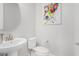 Bright powder room with a pedestal sink and a colorful piece of artwork at 25913 W Sands Dr, Buckeye, AZ 85396