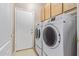 Efficient laundry room with front-load washer and dryer, plus overhead storage cabinets at 2605 N 115Th Dr, Avondale, AZ 85392