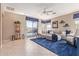 Bright living room with tile floors, blue rug, a ceiling fan, and sliding glass doors to the pool at 2605 N 115Th Dr, Avondale, AZ 85392