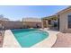 Inviting backyard pool with covered patio and surrounding desert landscaping at 2605 N 115Th Dr, Avondale, AZ 85392