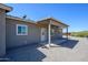 Back of home with a covered patio, windows, and desert landscaping at 27227 N 147Th Ave, Surprise, AZ 85387