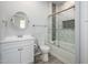 This bathroom features a glass door shower, white cabinets, a round mirror, and wood-look floors at 27227 N 147Th Ave, Surprise, AZ 85387