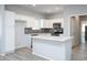 Modern kitchen with stainless steel appliances, a breakfast bar, and white cabinetry at 27227 N 147Th Ave, Surprise, AZ 85387