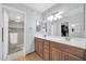 Bathroom featuring double sink vanity, large mirror, shower with glass door, and access to a walk-in closet at 2919 W Kerry Ln, Phoenix, AZ 85027