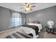 This cozy bedroom features gray walls, tan carpet, a fan, and curtains, with a white ladder shelf for storage at 2919 W Kerry Ln, Phoenix, AZ 85027