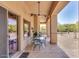 Long covered patio featuring desert landscape, ceiling fans, and a glass top dining table at 2924 W Here To There Dr, Phoenix, AZ 85086