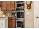 Stainless steel ovens and appliances with dark wood cabinetry in updated kitchen at 2924 W Here To There Dr, Phoenix, AZ 85086