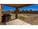 This covered patio overlooks a backyard with a BBQ at 2977 W Mira Dr, San Tan Valley, AZ 85144