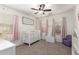 Charming Bedroom with a white crib, pink accents, and a ceiling fan for added comfort at 2977 W Mira Dr, San Tan Valley, AZ 85144