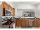 Open kitchen with a view into the living room, featuring stainless steel appliances and wood cabinets at 2977 W Mira Dr, San Tan Valley, AZ 85144