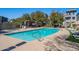 A community pool is surrounded by lounge chairs, and shade structure, perfect for relaxation and recreation at 300 N Gila Springs Blvd # 164, Chandler, AZ 85226