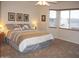 Cozy bedroom featuring a large bed, soft carpet, and ample natural light from the bay window at 3007 W Jordon Ln, Phoenix, AZ 85086