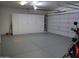 Clean garage featuring epoxy floor, white storage cabinets, and rolling garage door at 3007 W Jordon Ln, Phoenix, AZ 85086